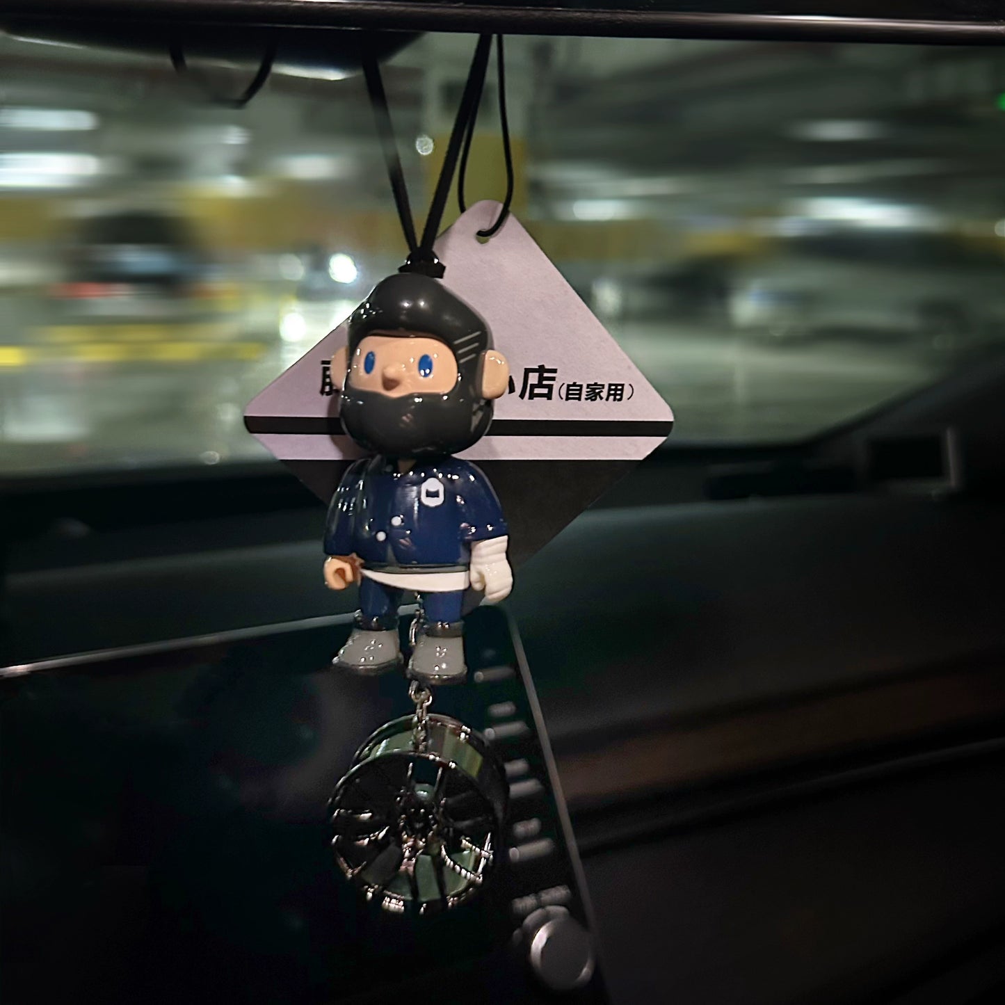 UrbanPop dashboard charm figure with pink hair, hoodie, and sneaker keychain hanging on rearview mirror – collectible streetwear vibe