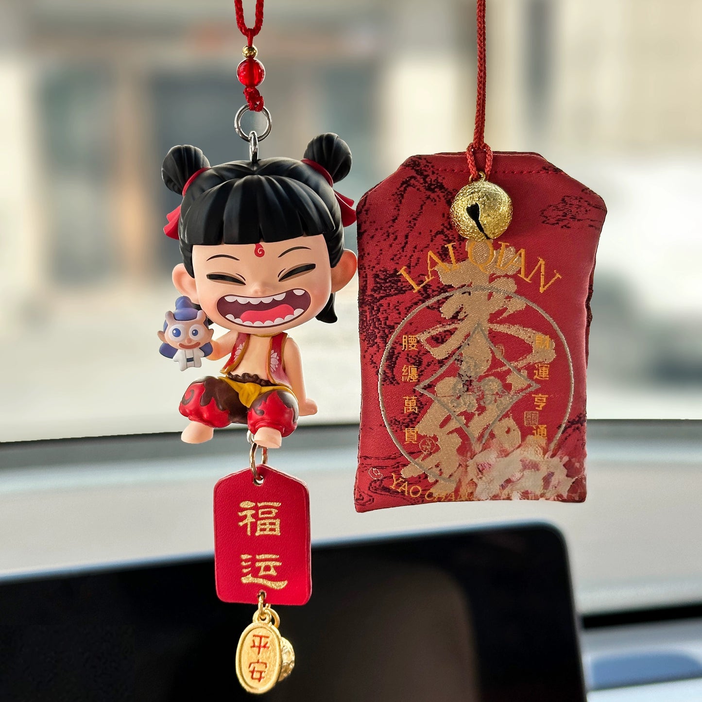 nezha inspired rear view mirror car charm with red ribbons and lucky amulet hanging