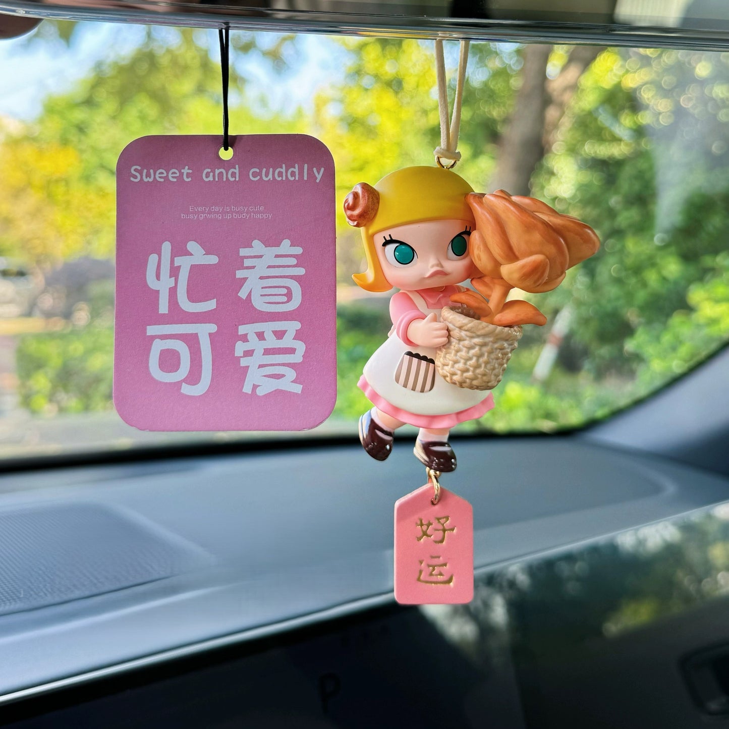 Luvbubu SweetDrive Girl dashboard doll in pink dress with good luck charm tag hanging in car interior