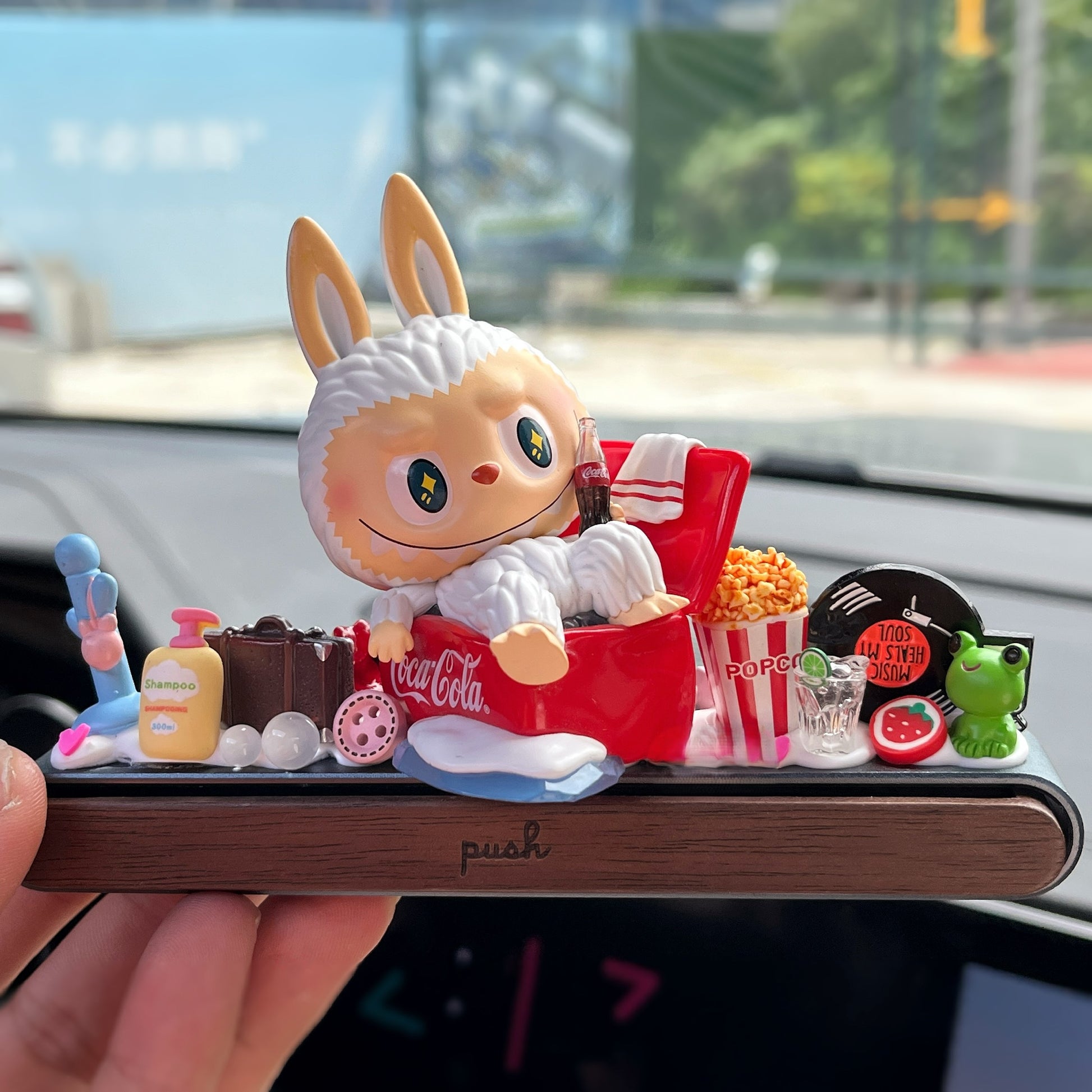 Lavubu™ figure on red sofa with parking plate and pastel gift box – handmade dashboard ornament for car interior decor