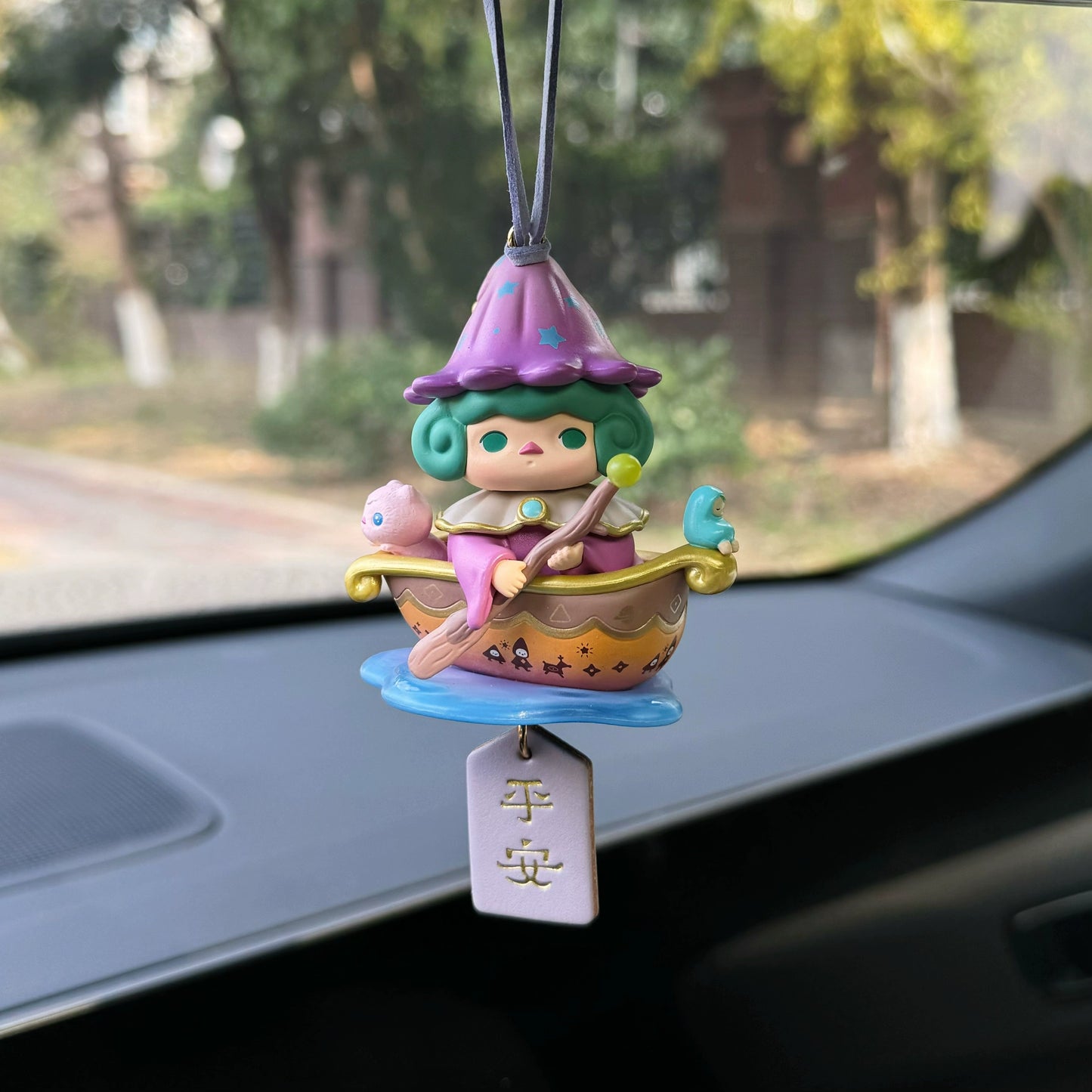 Luvbubu BubbleBear charm doll in pink outfit with bear hoodie and crystal ball, hanging on car dashboard with Lucky tag