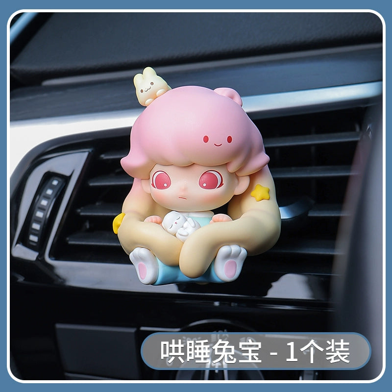 Car air freshener shaped like a cartoon character with pink hair and a bear on a car vent.