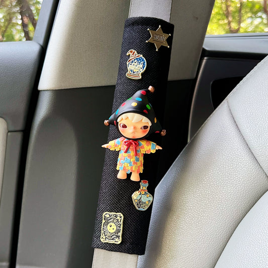 Car seat belt cover with colorful clown design and pins on a car interior background