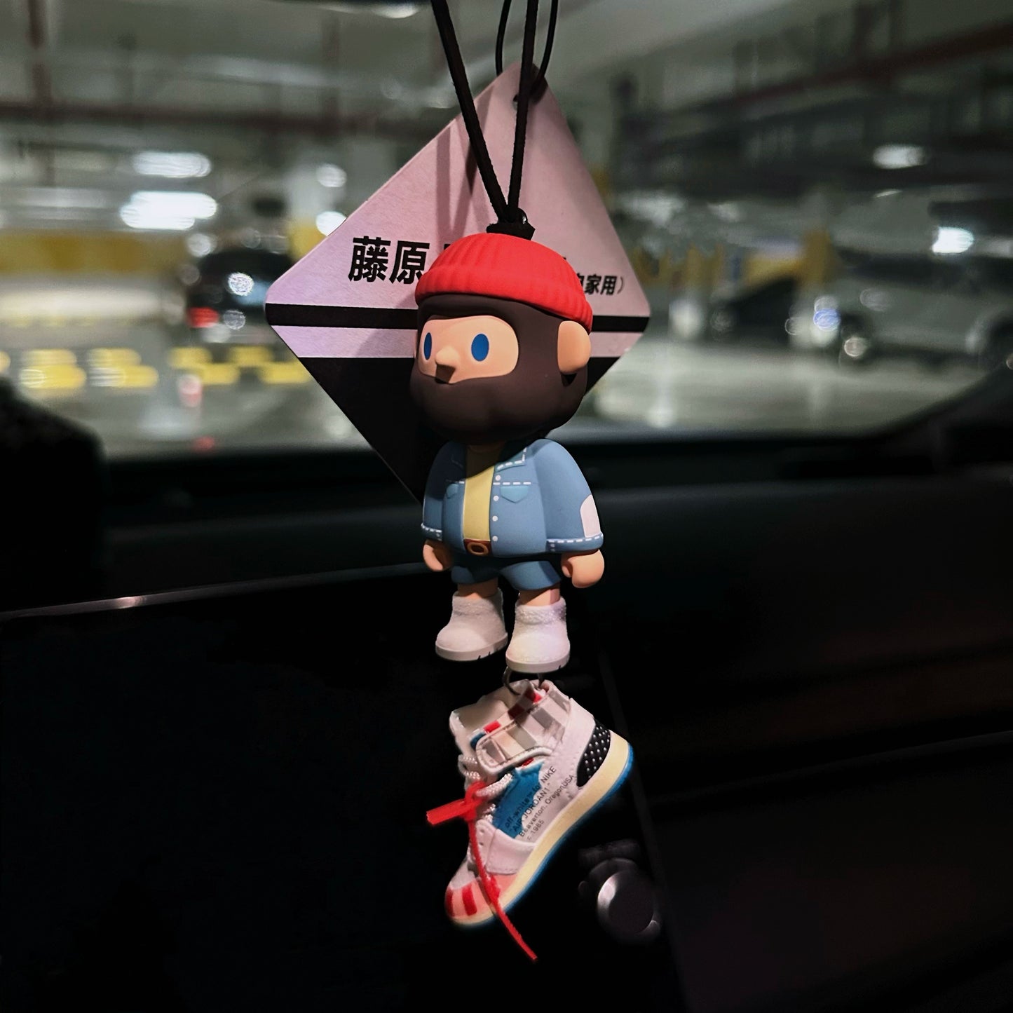 UrbanPop dashboard charm figure with pink hair, hoodie, and sneaker keychain hanging on rearview mirror – collectible streetwear vibe