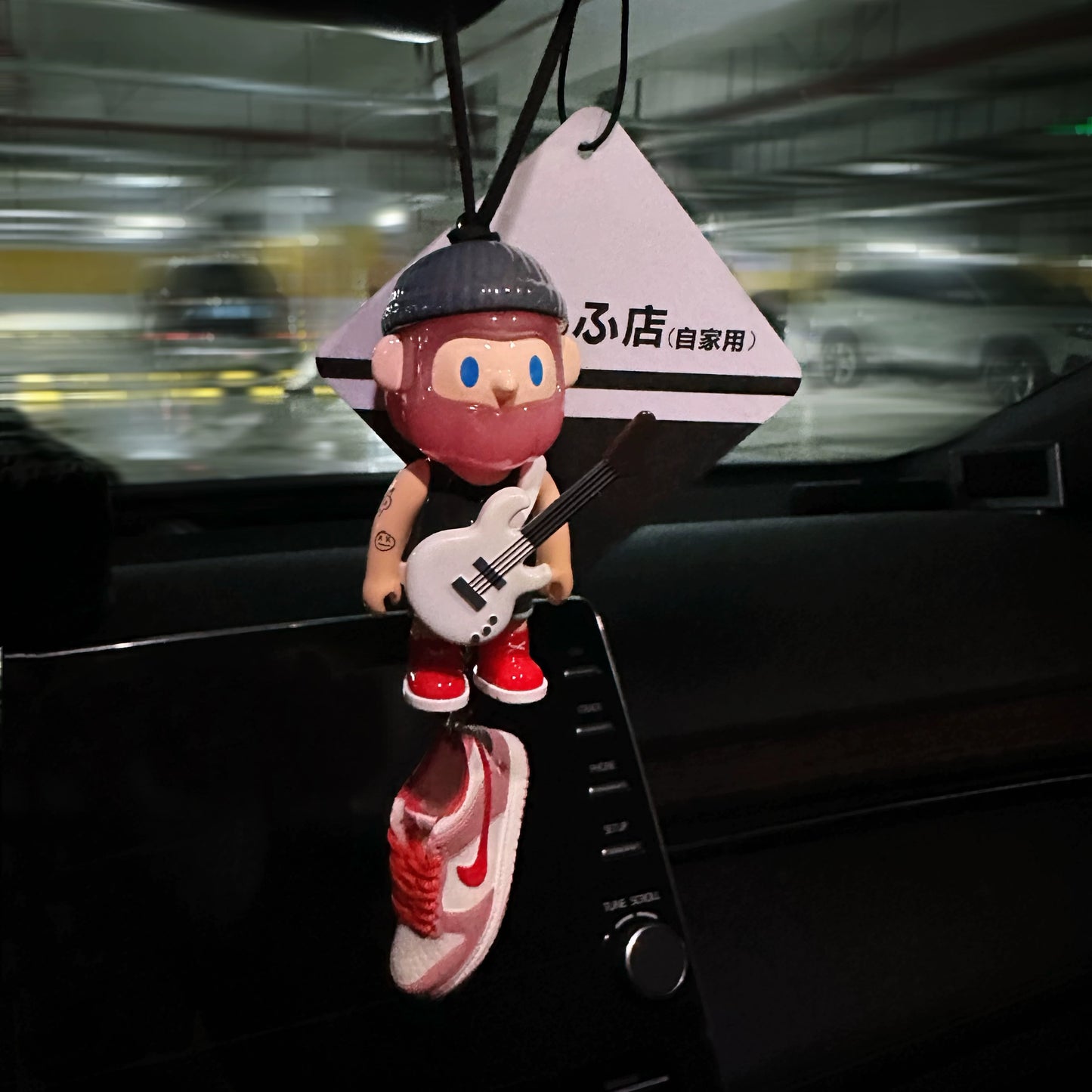 UrbanPop dashboard charm figure with pink hair, hoodie, and sneaker keychain hanging on rearview mirror – collectible streetwear vibe