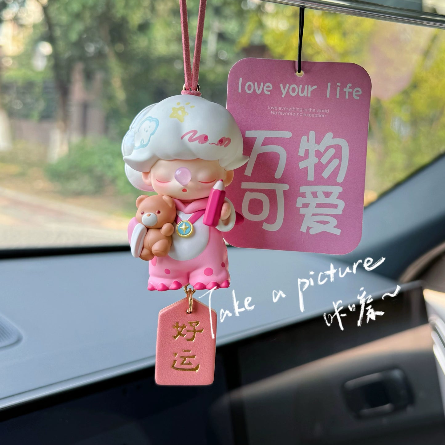 Dreamoo sailor figurine with blue orb and red Peace & Joy tag on car dashboard – soft aesthetic collectible charm