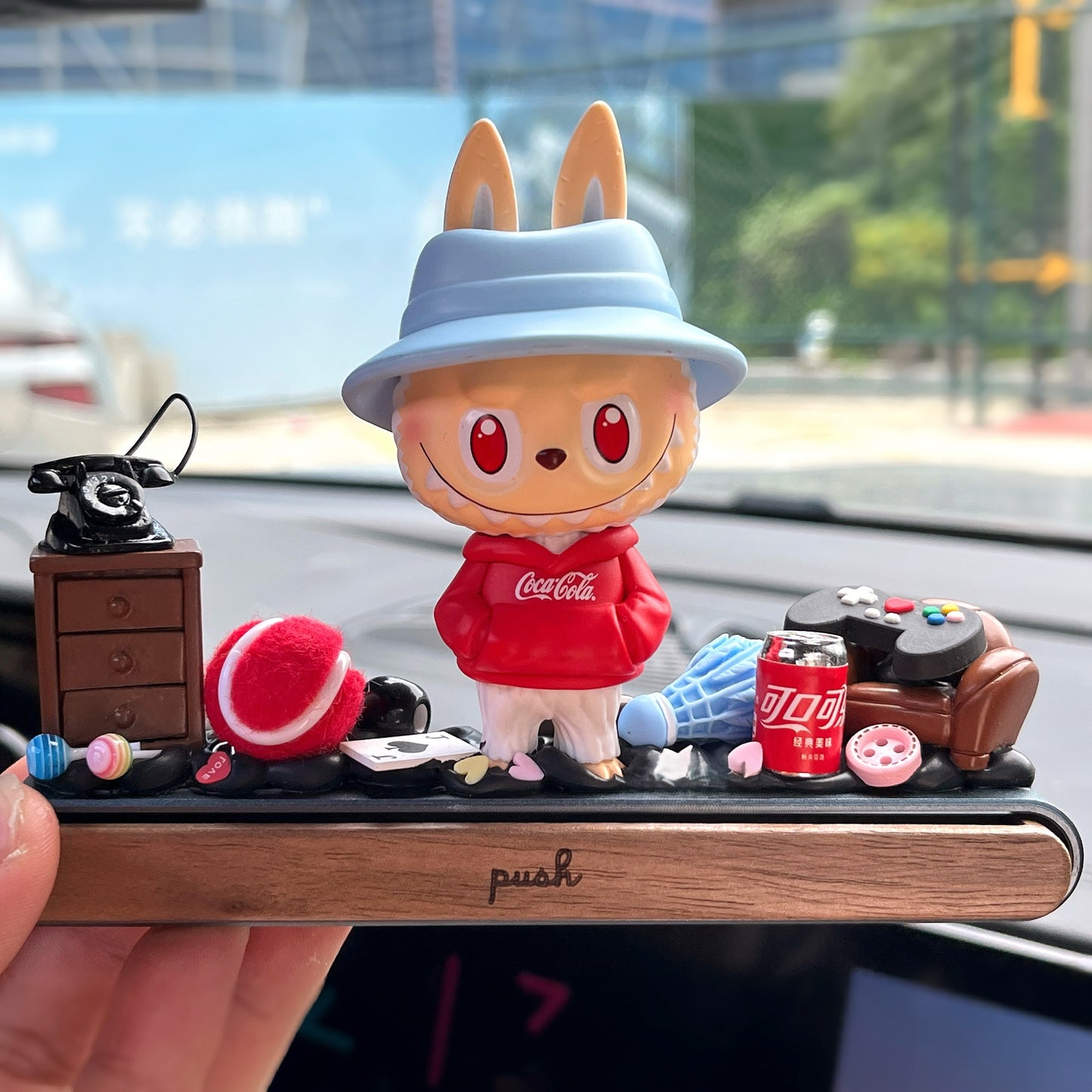 Lavubu™ figure on red sofa with parking plate and pastel gift box – handmade dashboard ornament for car interior decor